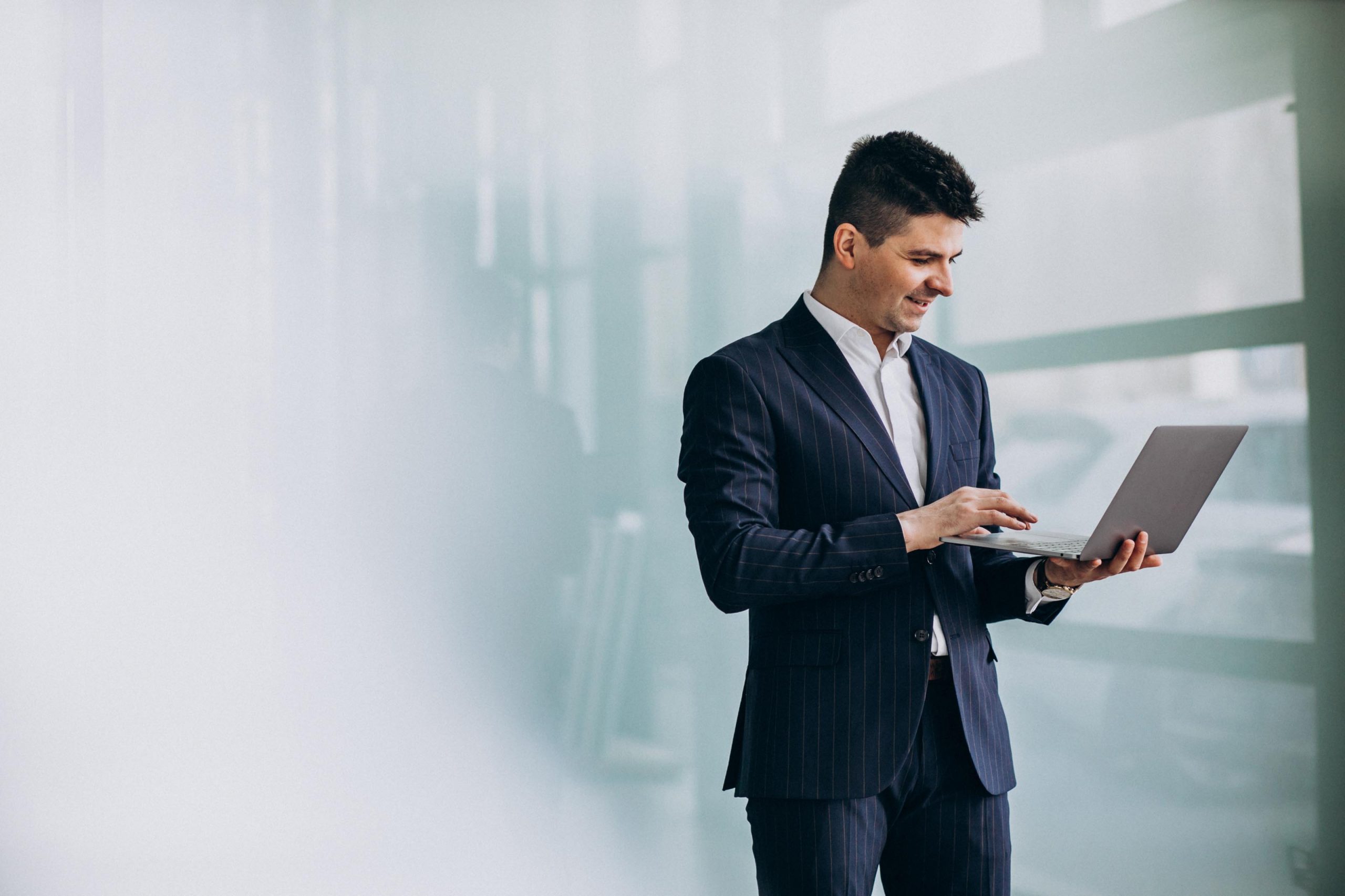 young-handsome-business-man-with-laptop-office-scaled